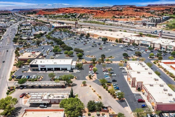Retail complex featuring extensive parking, multiple commercial buildings, and landscaping elements
