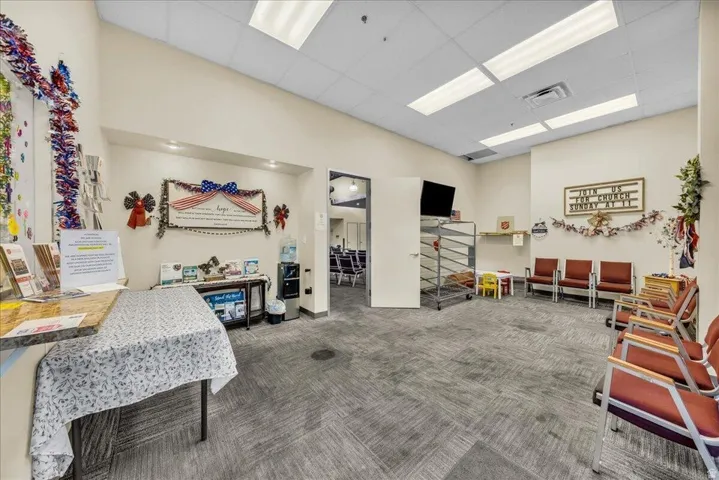Reception area featuring neutral wall tones, recessed lighting, and patterned carpet flooring
