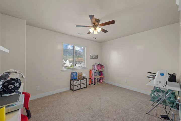 Carpeted interior room with neutral wall tones and white baseboards