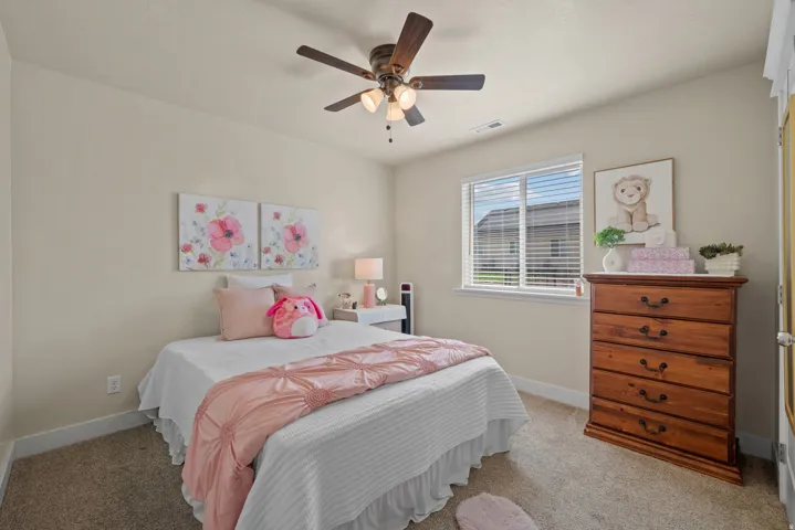 Carpeted room featuring a ceiling fan with integrated lighting, a window with horizontal blinds, and neutral wall paint