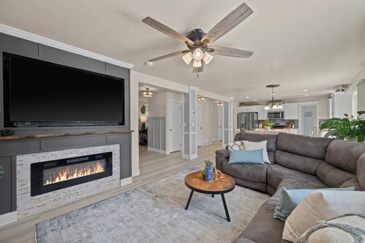 Living area featuring a built-in media center with an electric fireplace, wood-finish flooring, recessed lighting, and a ceiling fan