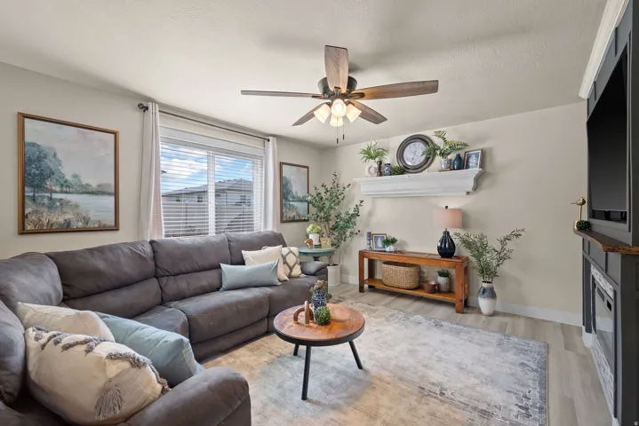 Living area featuring light wood-finish flooring and a ceiling fan