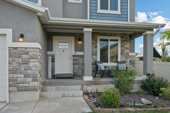 Covered porch entry featuring stone veneer accents