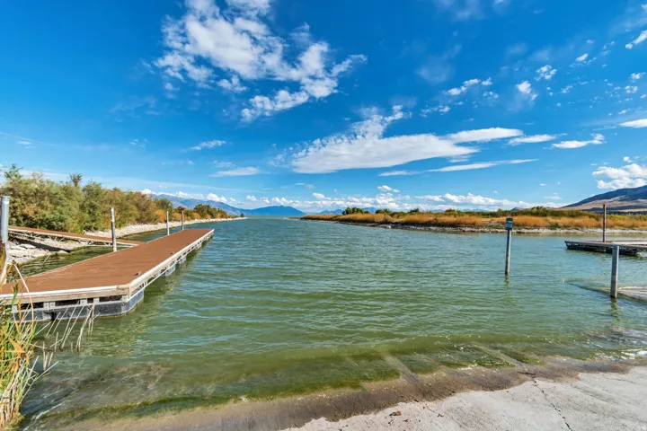 Waterfront setting featuring multiple floating docks, a concrete boat ramp, and distant mountain ranges