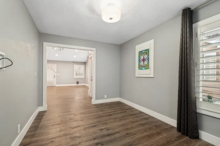 Interior room featuring wood-finish flooring, light gray wall paint, and white baseboards