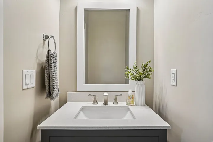 Bathroom vanity featuring a rectangular undermount sink, a light-toned countertop, and a dark-toned cabinet base