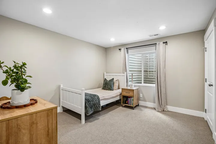 Carpeted room featuring recessed lighting, a window with horizontal blinds, and a white interior door with matte black hardware