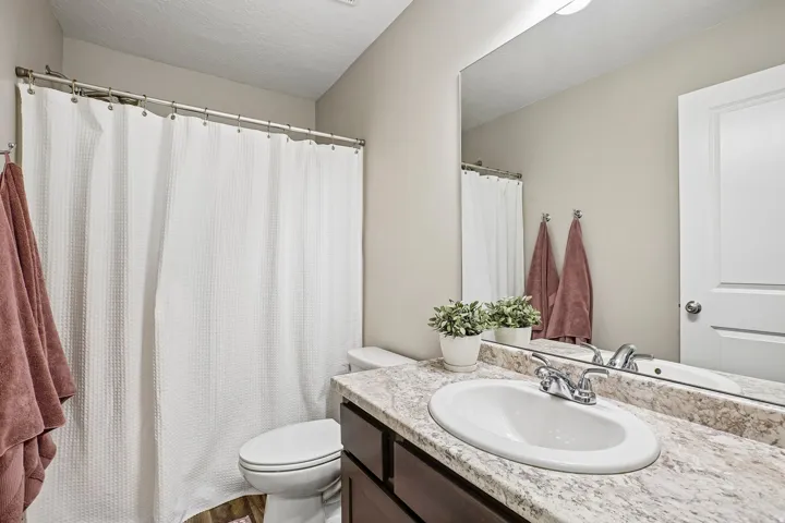 Bathroom featuring a built-in vanity with a countertop, an undermount sink, and a chrome faucet