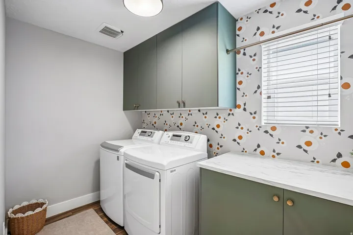 Laundry space featuring custom cabinetry, a built-in countertop, and an overhead light fixture