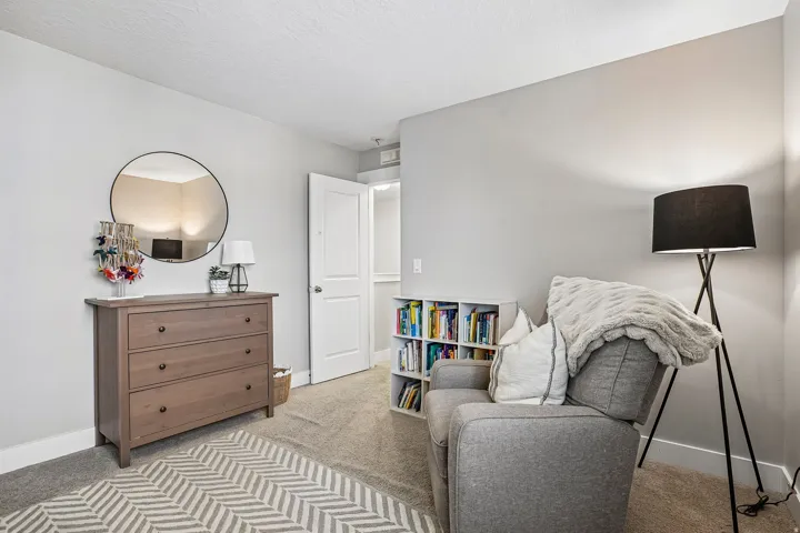 Neutral wall color, carpeted flooring, white trim, and a white interior door