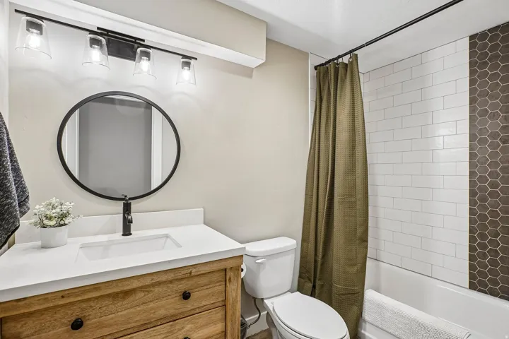 Bathroom featuring a contemporary vanity with wood-finish cabinetry, a white countertop, and a rectangular undermount sink
