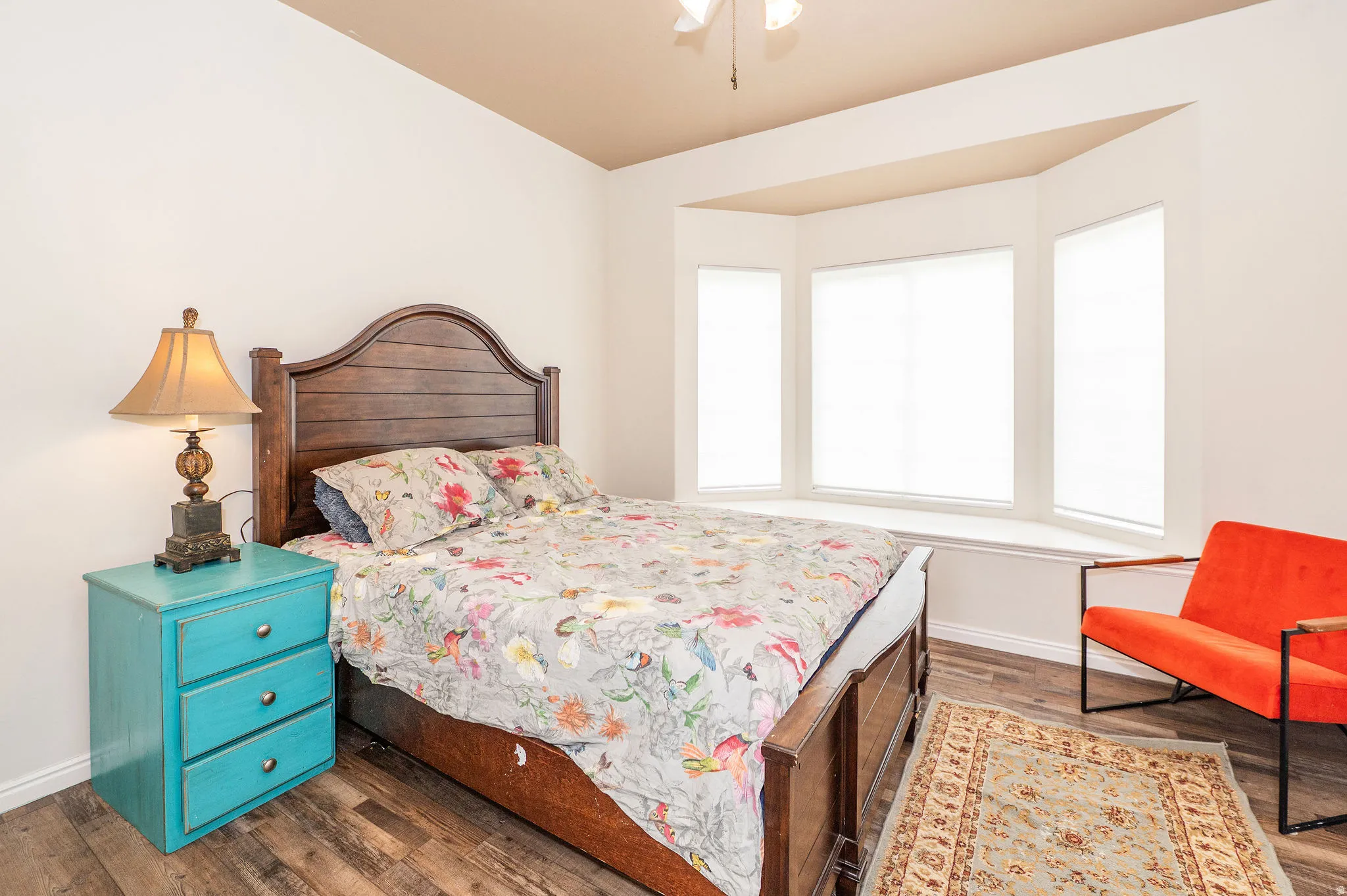 Spacious room with wood-finish flooring and a ceiling fan
