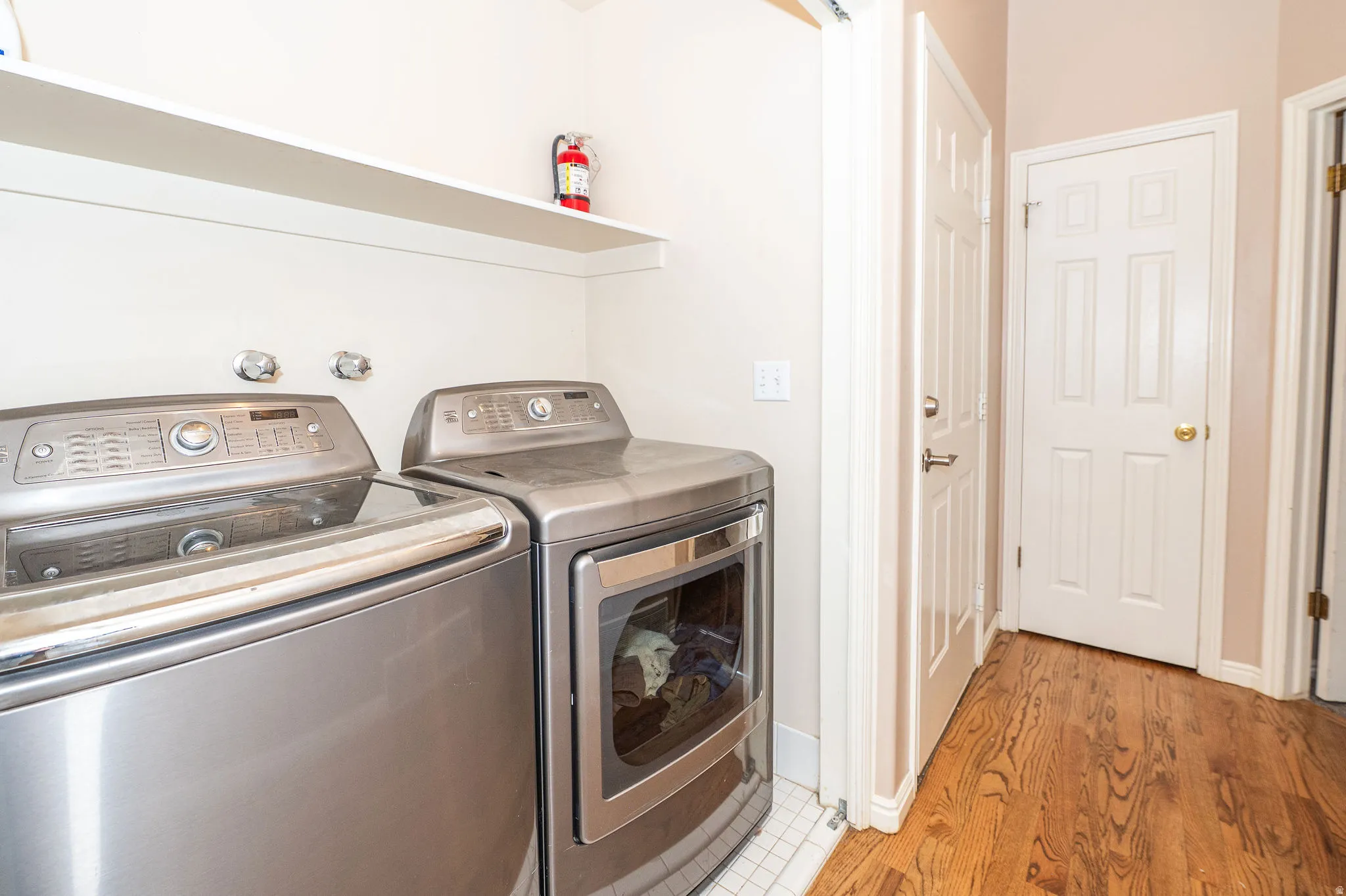 Dedicated laundry area featuring a white floating shelf and two permanent doors