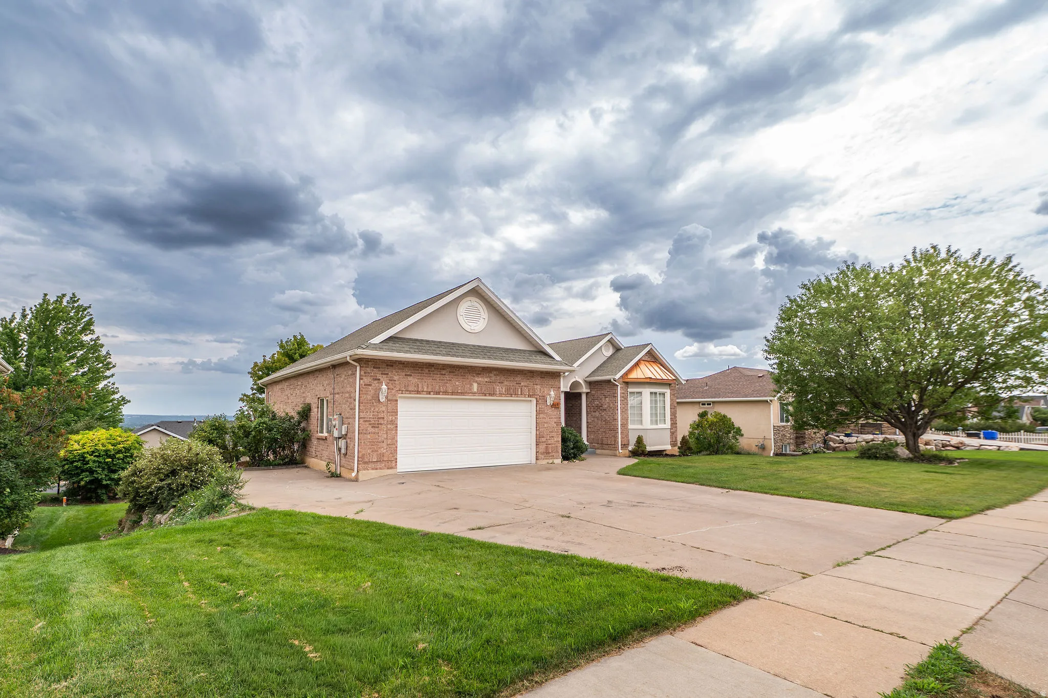 Brick and siding exterior featuring a prominent two-car garage