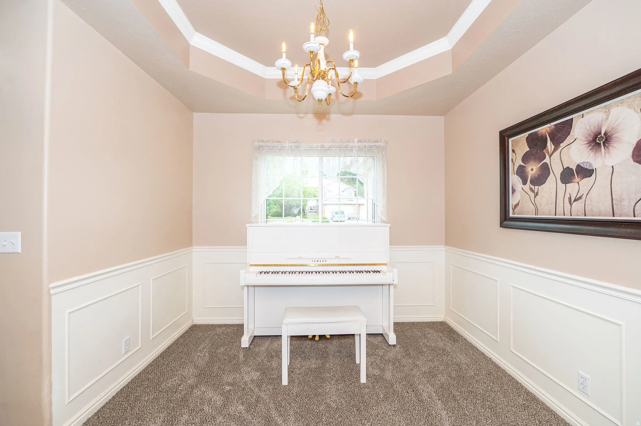Room featuring wainscoting with decorative paneling and a tray ceiling