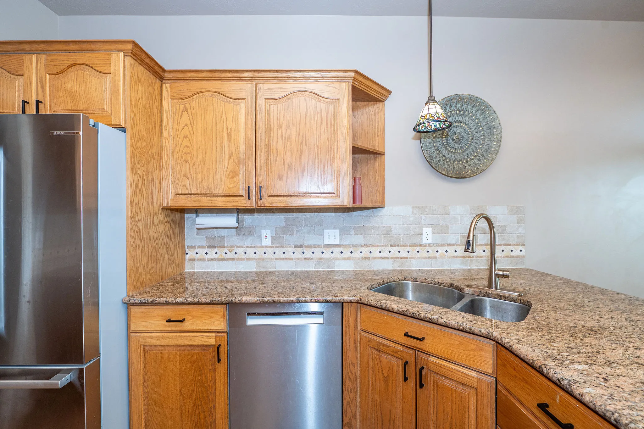 Kitchen featuring wood cabinetry, granite-finish countertops, and a tiled backsplash