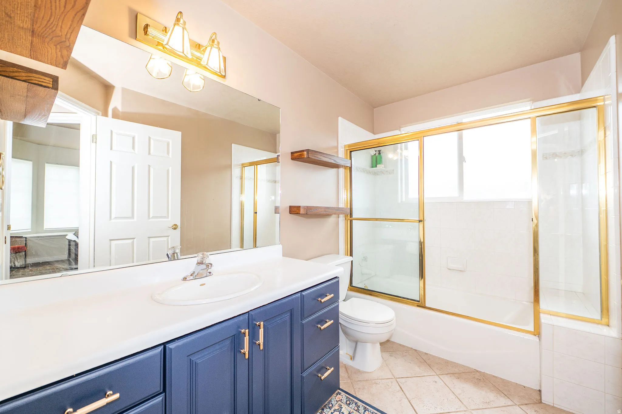 Bathroom featuring a blue vanity with gold hardware, a white countertop, and an integrated sink