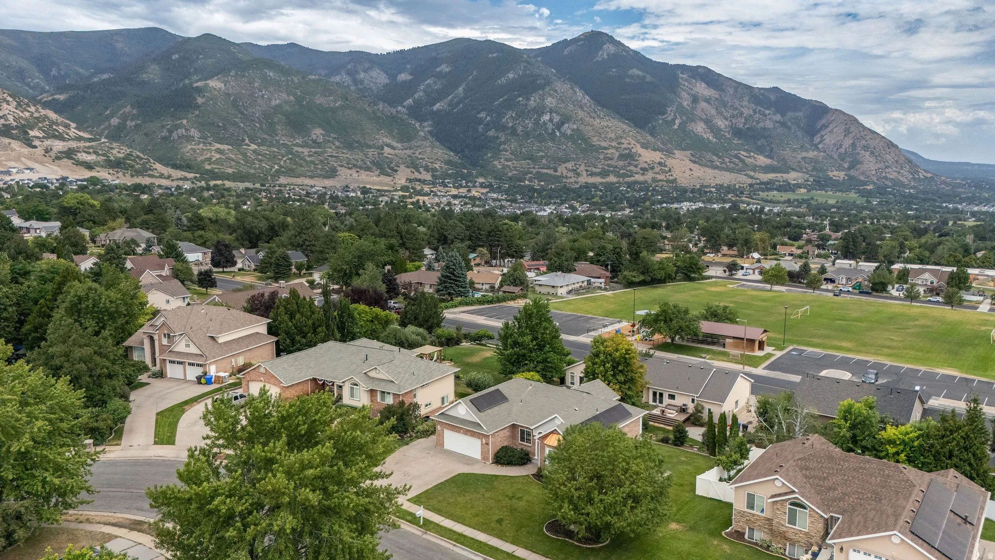 Expansive residential area featuring established homes, mature trees, and a distant mountain backdrop
