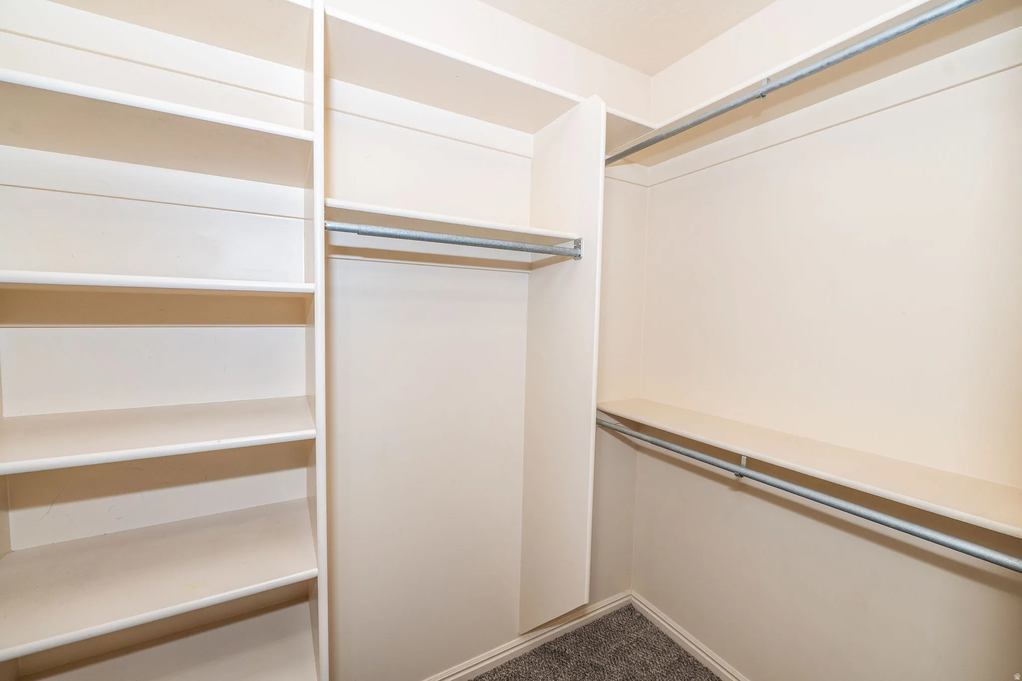 Custom closet system featuring extensive shelving and multiple hanging rods