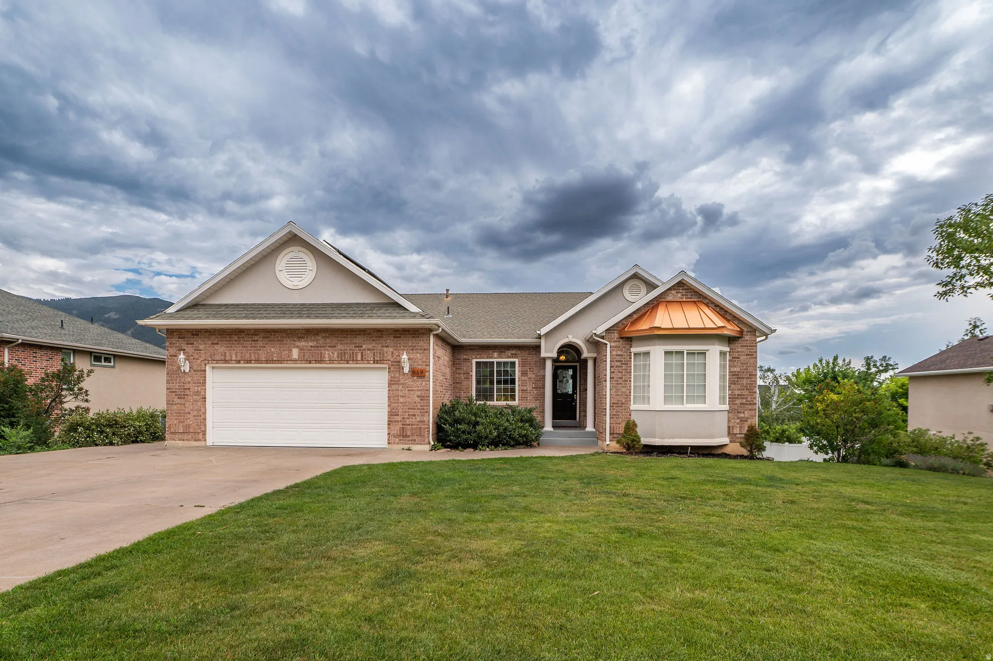 Brick exterior with a prominent copper bay window accent