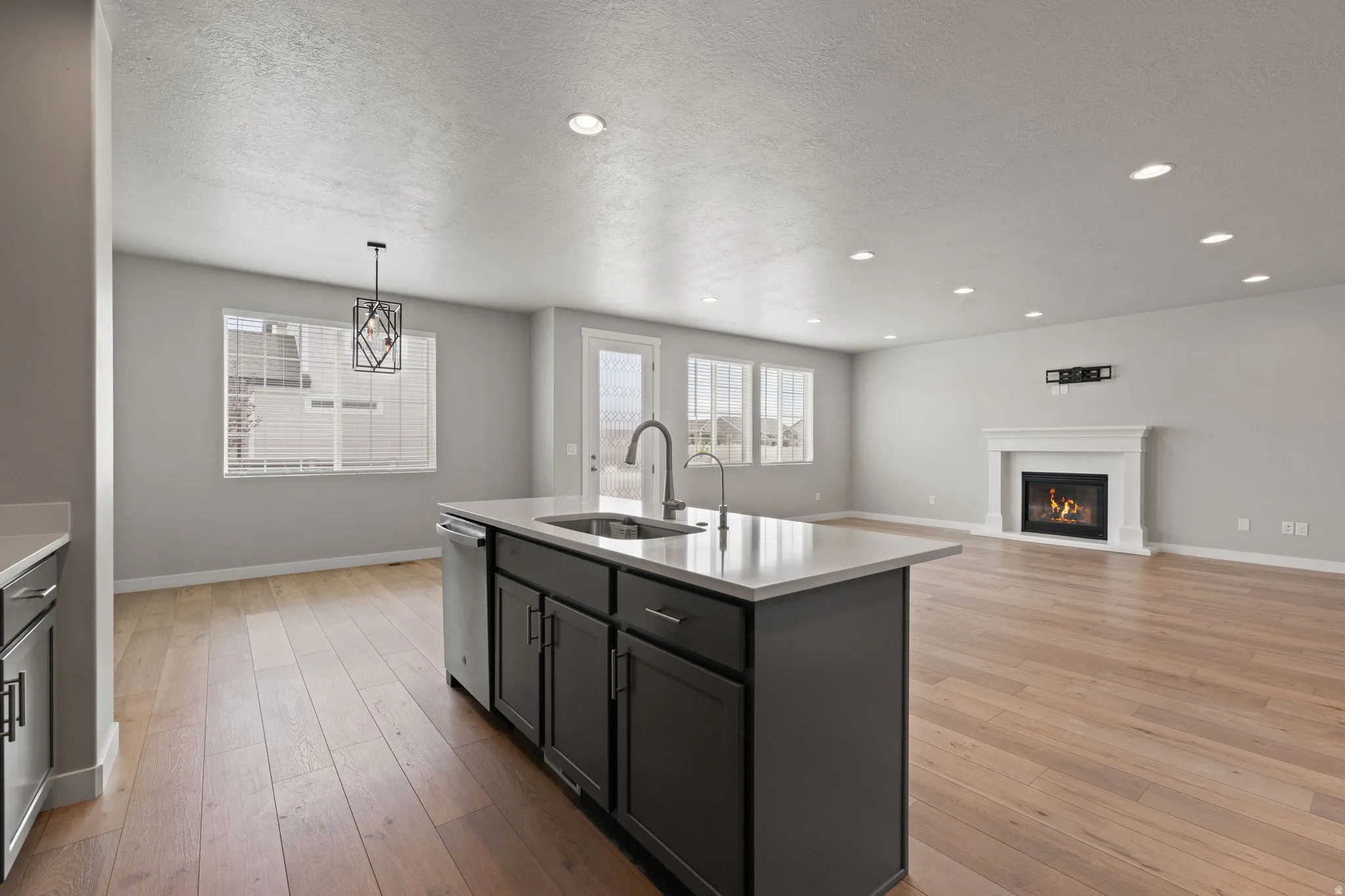 Open-concept living area featuring wood-finish flooring and recessed lighting