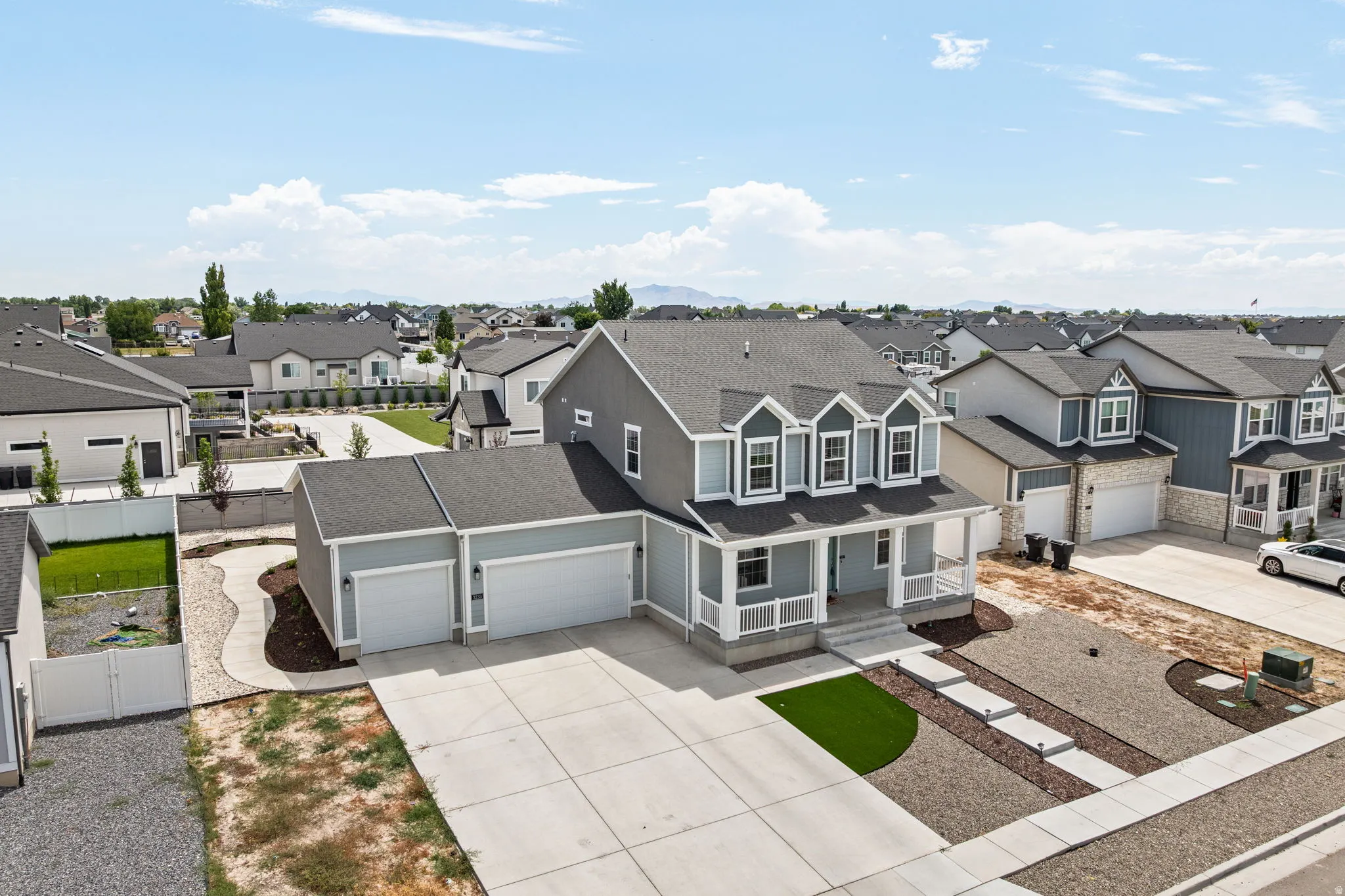 Contemporary two-story home featuring a three-car garage and a covered front porch