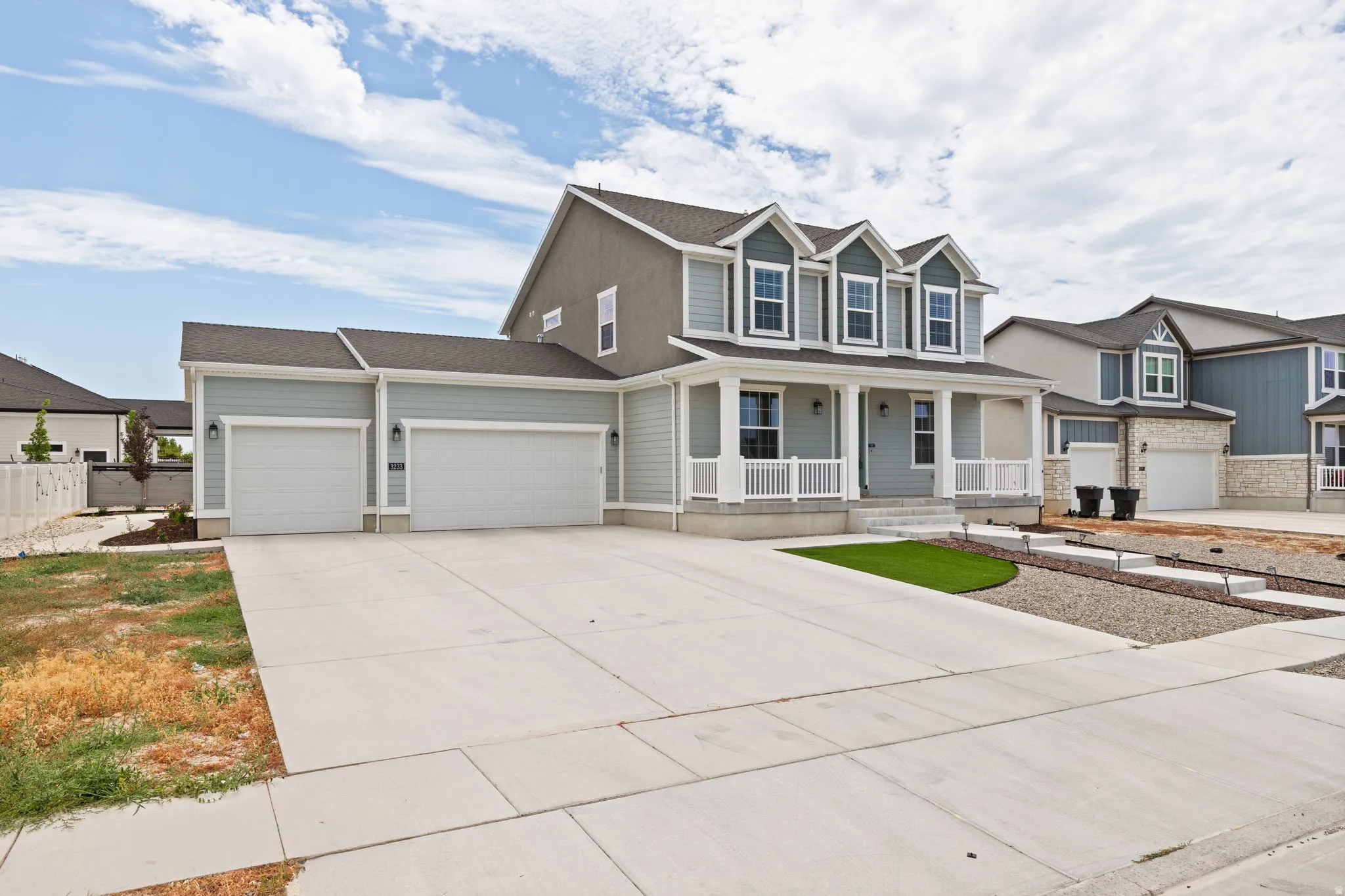 Two-story residence featuring a covered front porch with white railings and columns