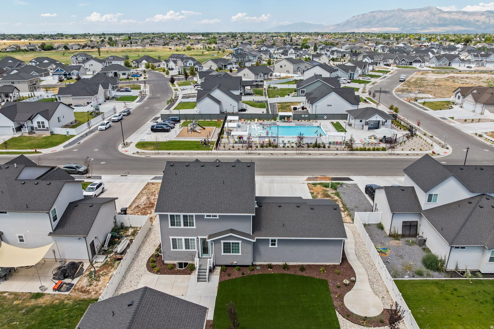Modern residential development featuring a community swimming pool, playground, and paved streets