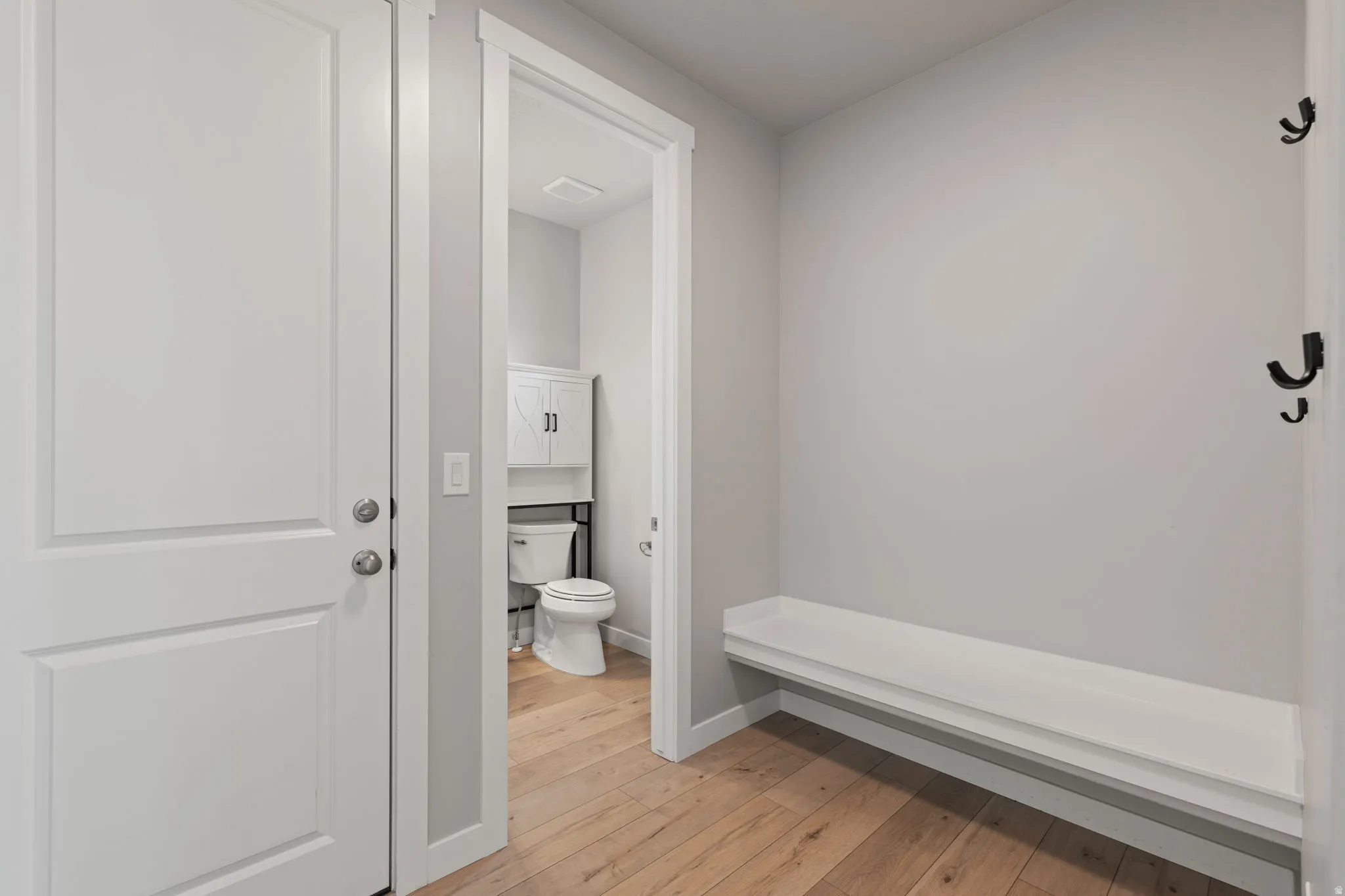 Hardwood-finish flooring throughout, featuring a built-in bench with wall-mounted hooks