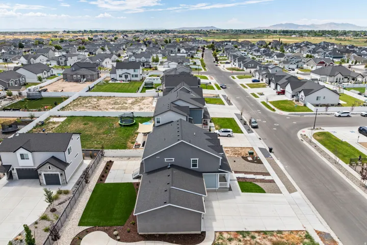 Expansive residential development featuring a variety of single-family homes with dark roofing, light-colored exteriors, and attached garages