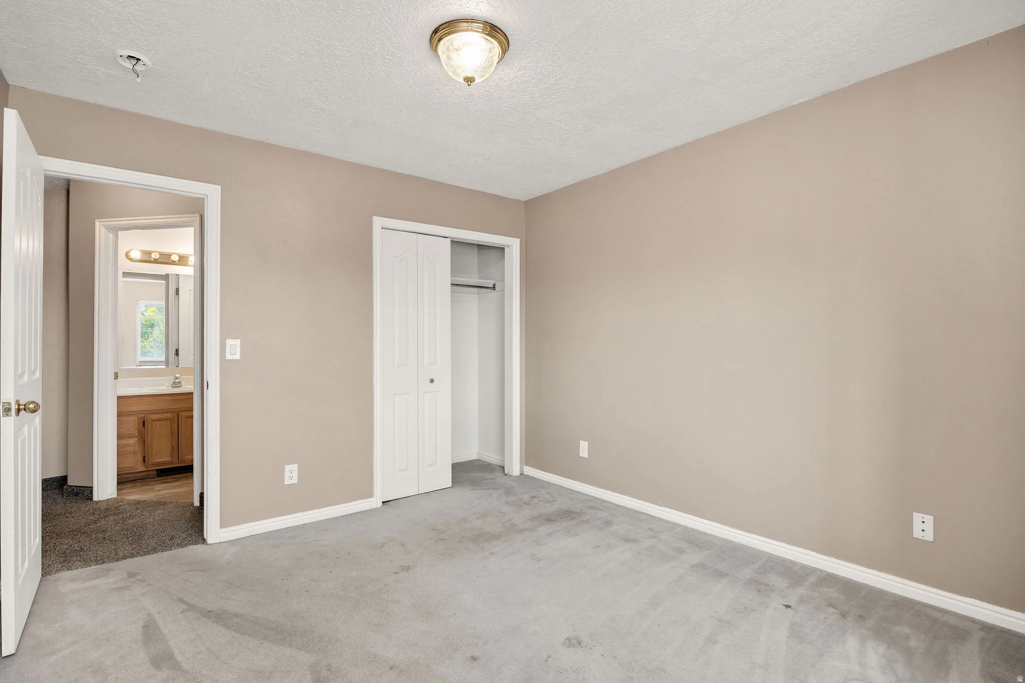 Bedroom featuring light-toned walls and gray carpeting