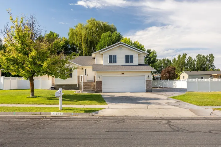 Two-story residence featuring light-colored siding, a two-car garage, and a concrete driveway