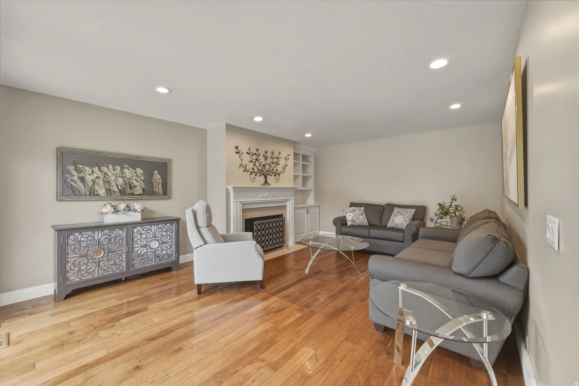 Living area featuring wood-finish flooring, recessed lighting, and a fireplace with mantle