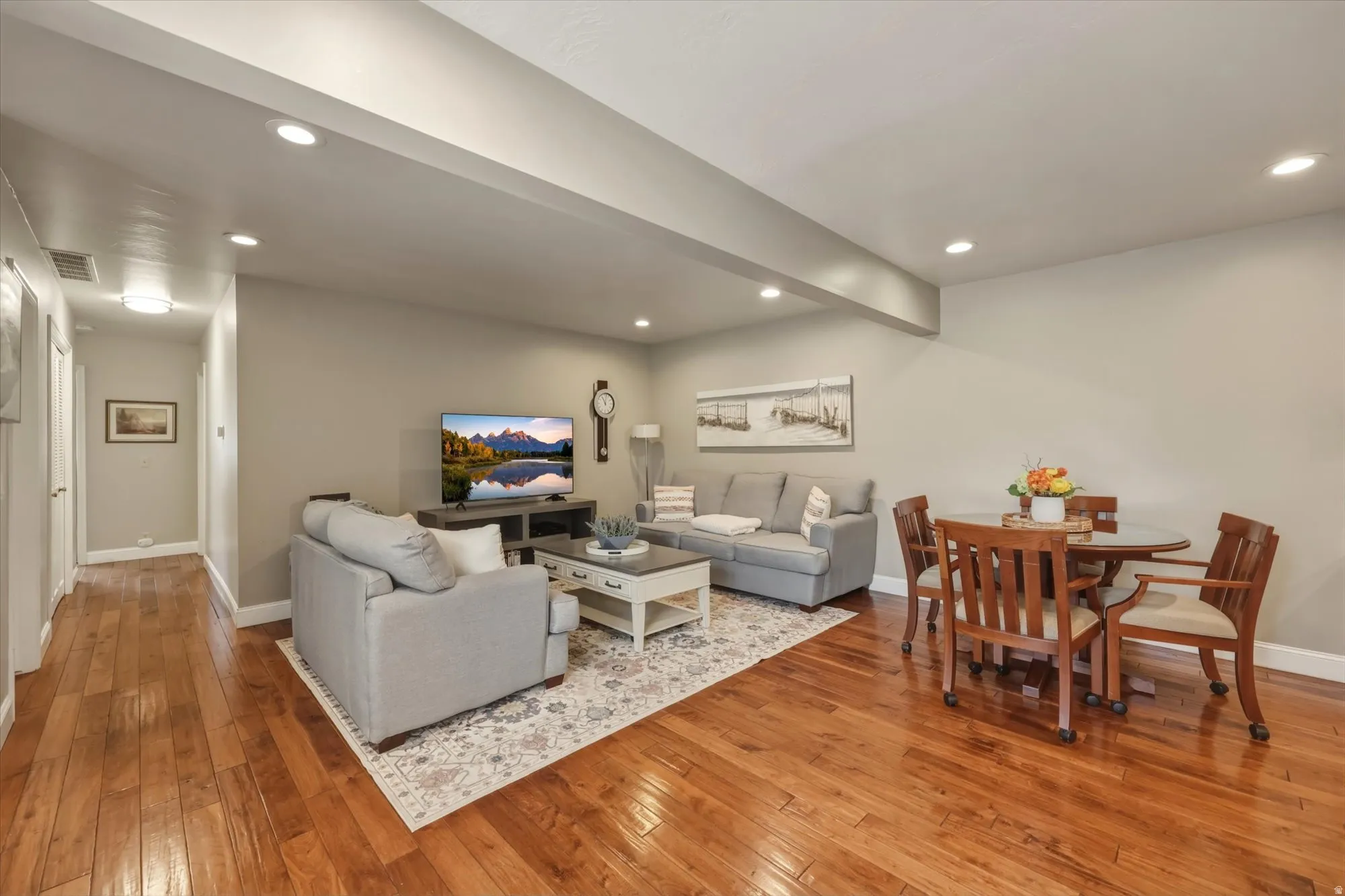 Living and dining area featuring wood-finish flooring, recessed lighting, and a neutral color palette