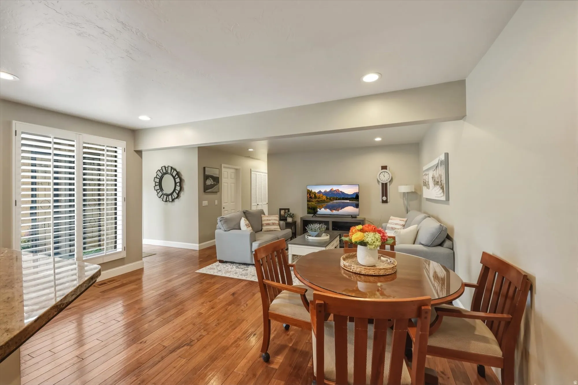 Open-concept living space featuring wood-finish flooring, recessed lighting, and a granite-look counter
