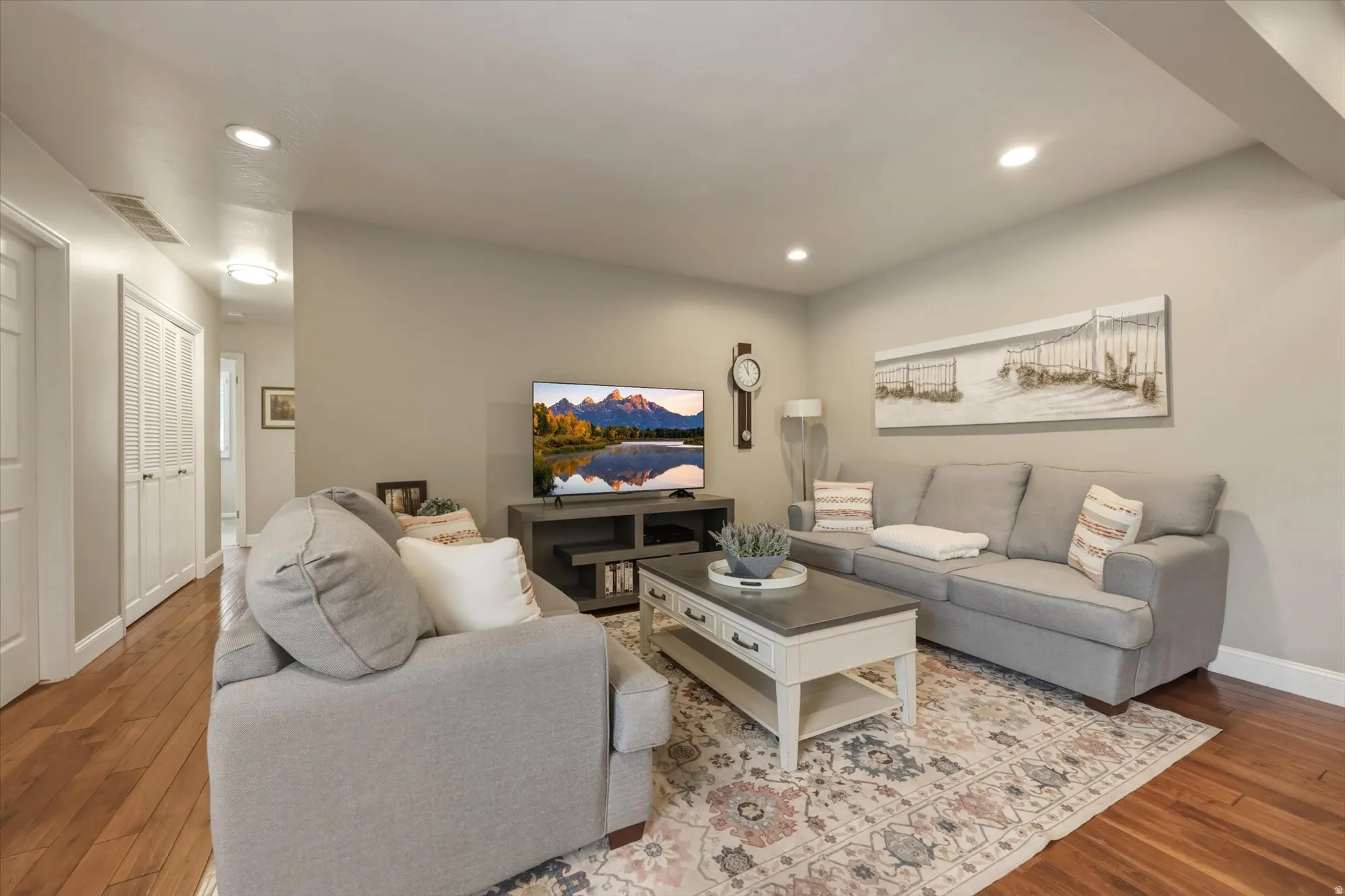 Spacious living area featuring wood-finish flooring, recessed lighting, and neutral wall tones