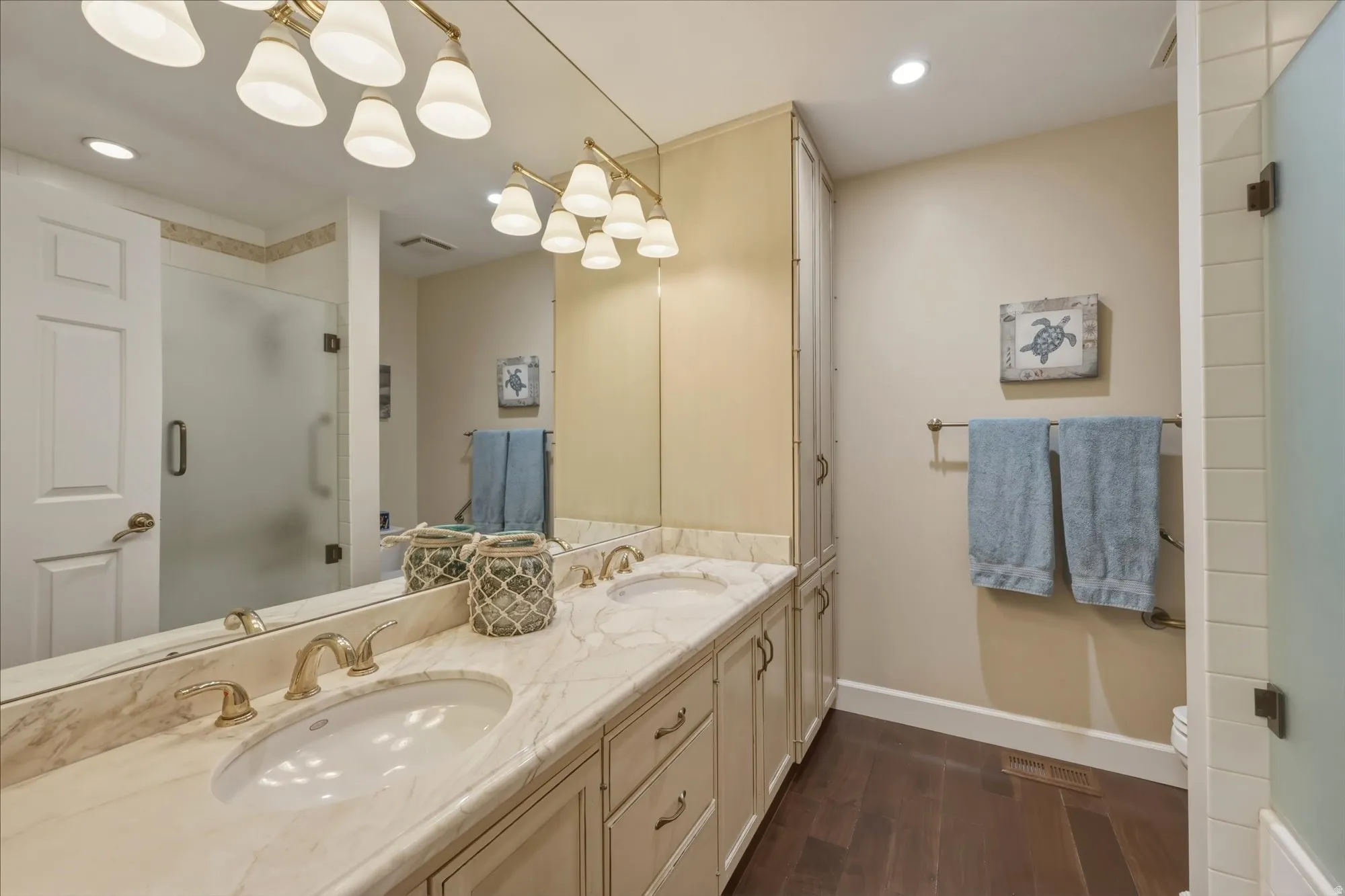 Double vanity with integrated sinks, light-toned countertop, and brass-finish fixtures