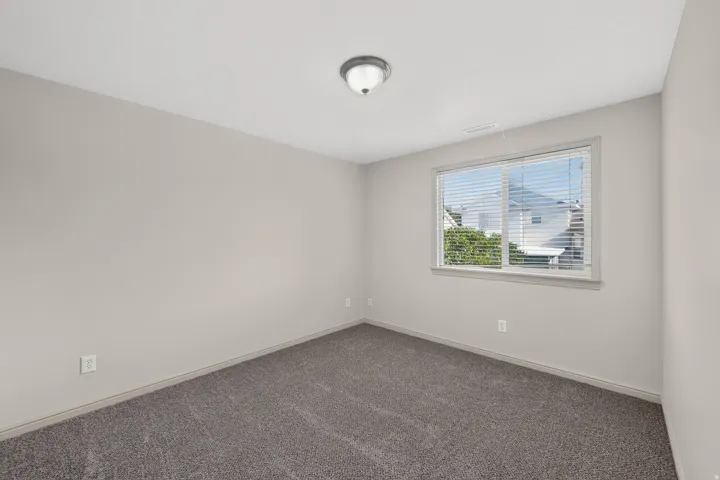 Neutral-toned walls complement the gray carpeting