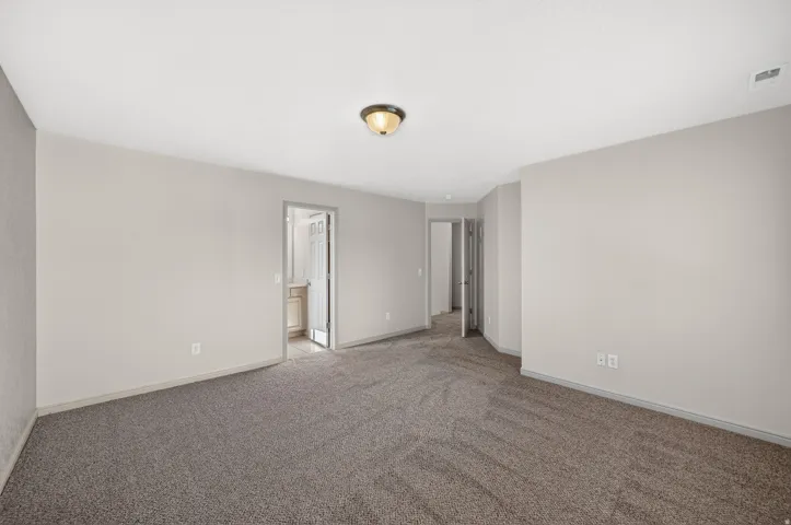 Neutral-toned walls complement the gray carpeting
