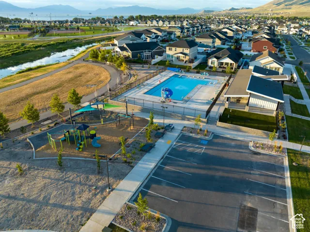 Community amenities featuring a fenced swimming pool, adjacent clubhouse, and a dedicated playground