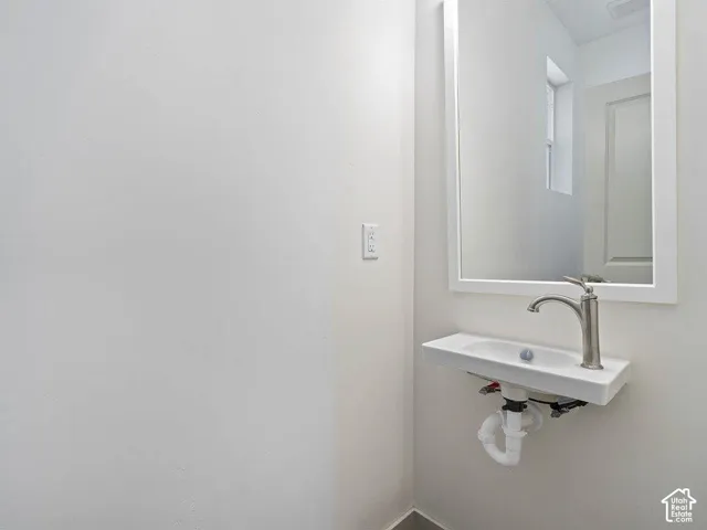 Wall-mounted rectangular sink with a single-handle brushed nickel faucet