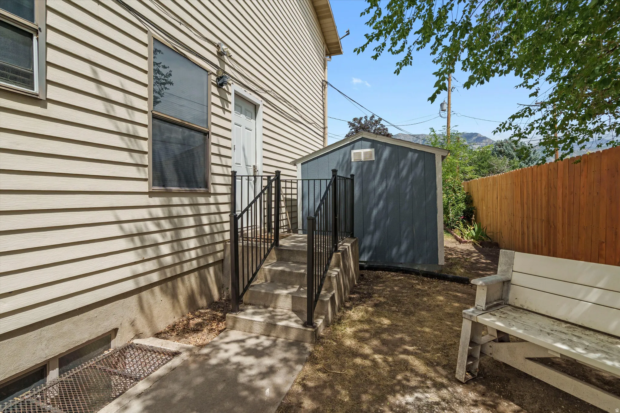 Exterior siding with multiple windows and basement entrance.
