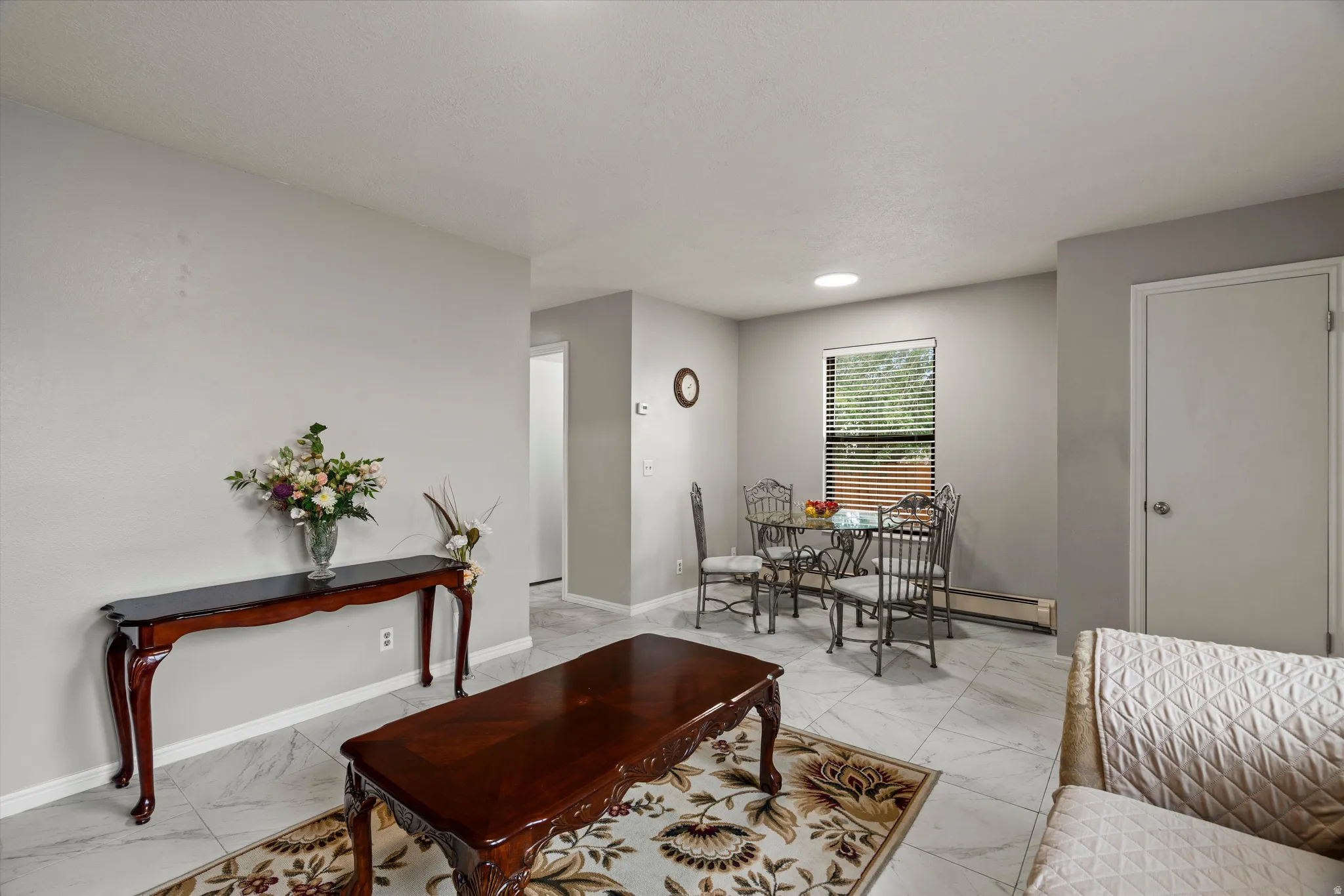 Spacious interior featuring light gray walls, recessed lighting, and large format tile flooring