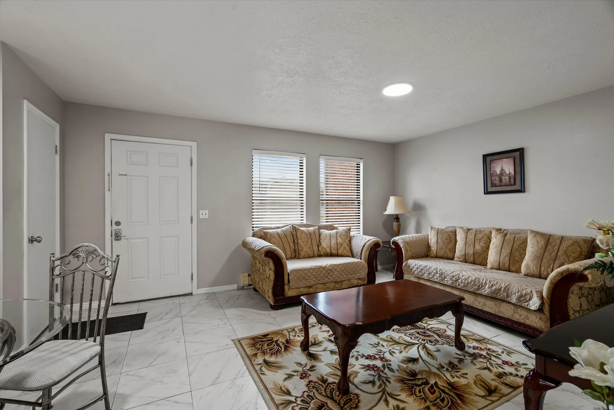 Living area featuring light gray walls, white paneled doors, and white tile flooring