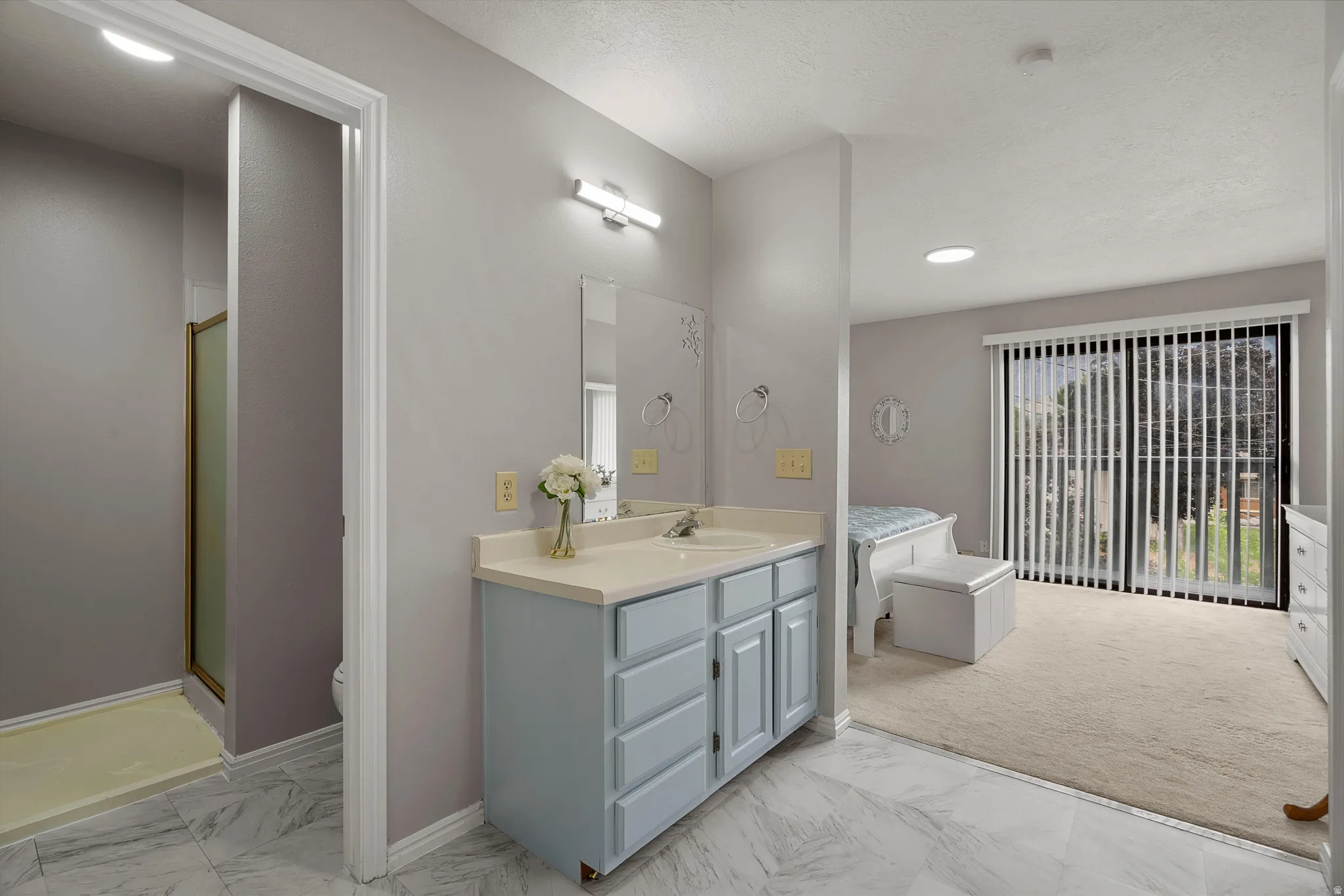 Primary bathroom vanity featuring a light blue cabinet, countertop with an integrated sink, and an overhead light fixture