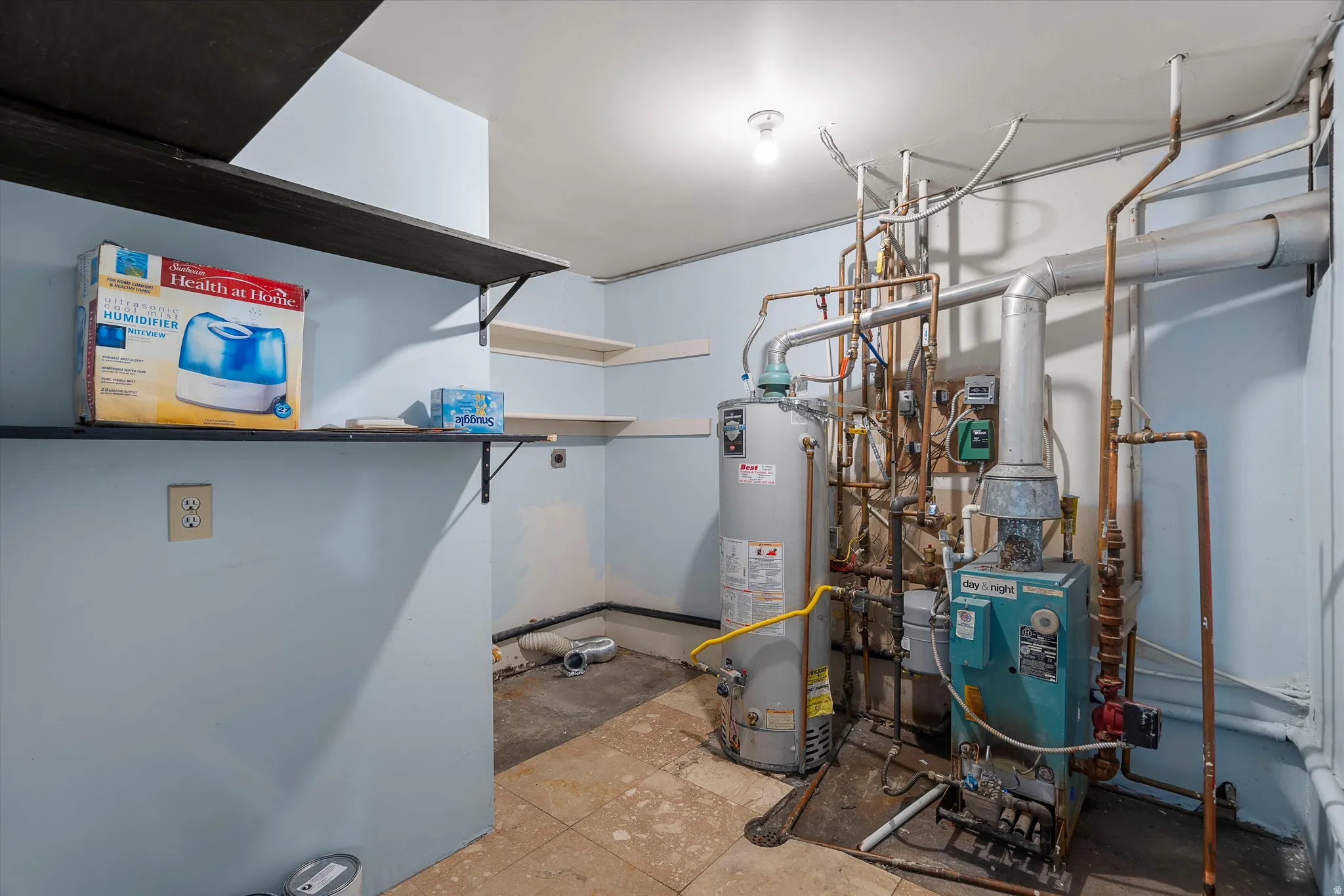 Utility room featuring a water heater, boiler system, and washer/dryer connections.