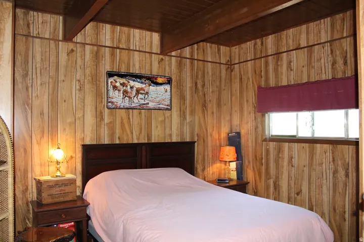 Room featuring wood paneling walls and a wood-finish ceiling with exposed beams