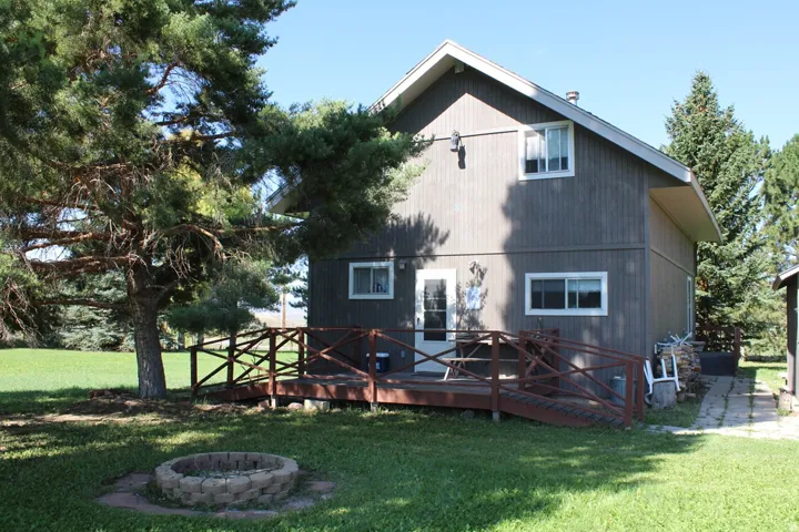 Two-story exterior with horizontal siding, featuring a wood deck with ramp access