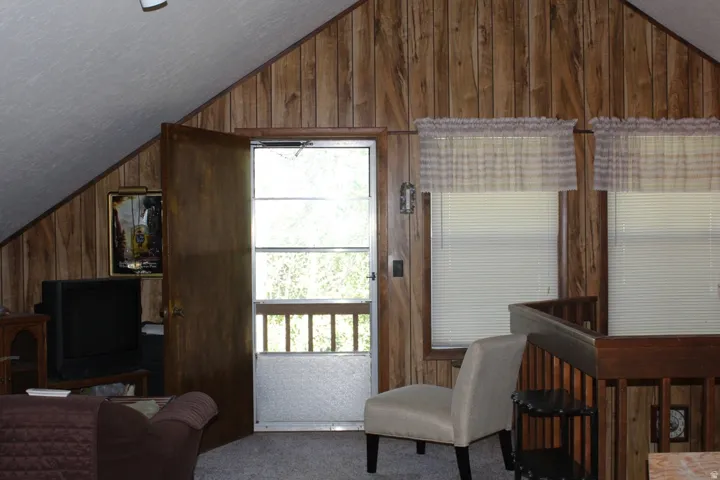 Sloped ceiling with white paneling and wood-paneled walls
