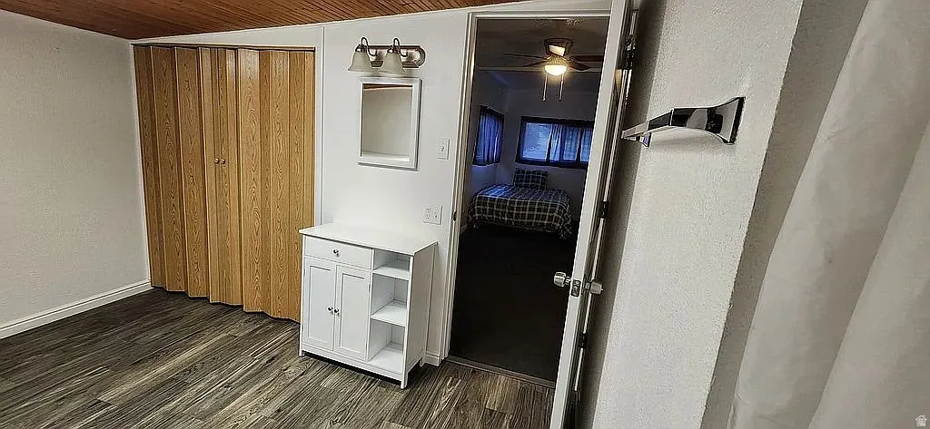 Wood-finish flooring throughout, featuring a wood plank ceiling, and accordion-style closet doors